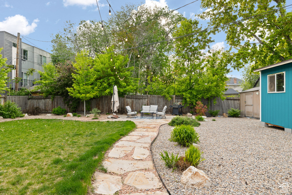 View of yard with a storage unit, a patio area, and an outdoor structure