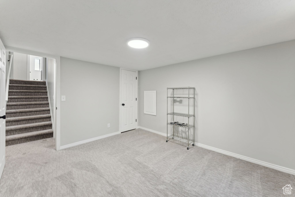 Finished below grade area featuring stairway, carpet, and baseboards