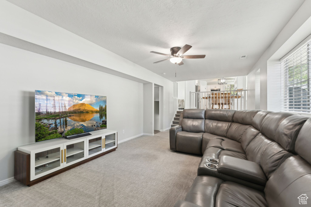 Living area with ceiling fan, carpet floors, and baseboards