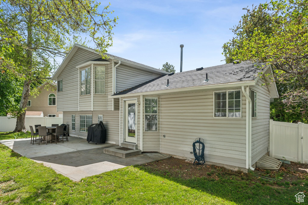 Back of house featuring a patio area and a shingled roof