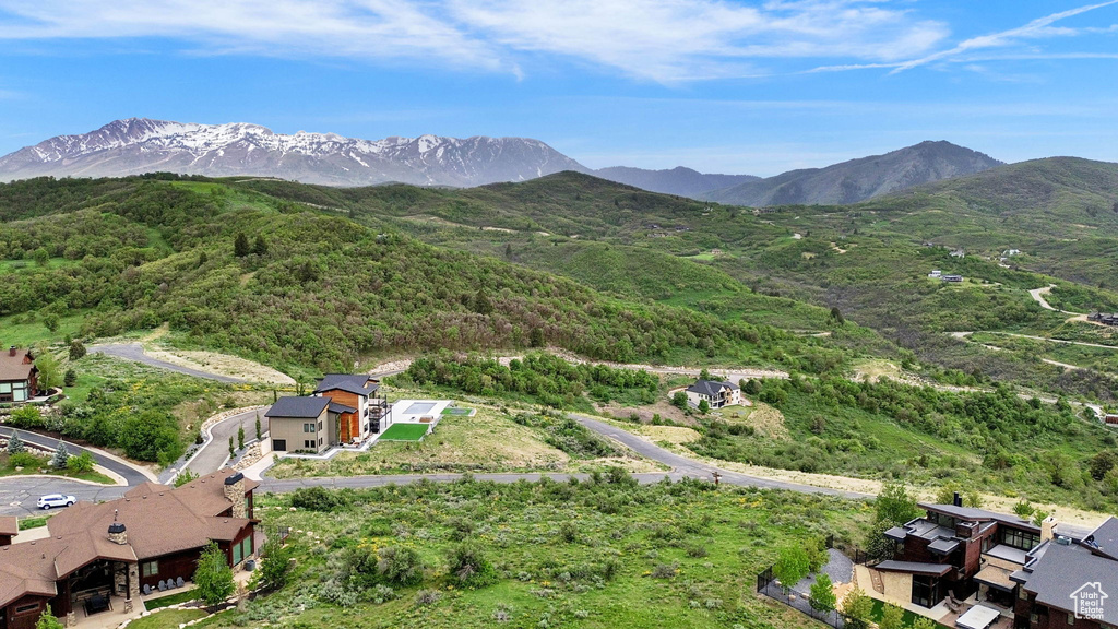 Aerial view of property and surrounding area featuring a mountainous background