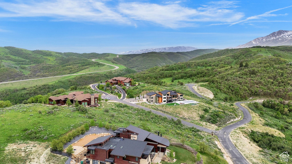 Aerial view of property and surrounding area featuring a mountainous background