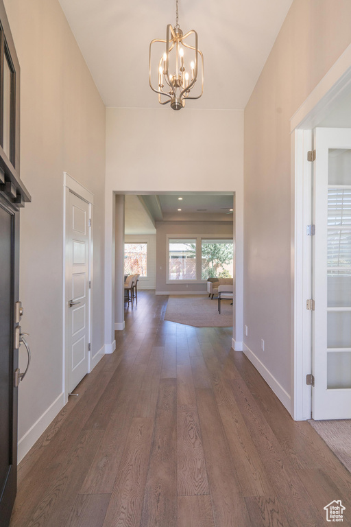 Entryway featuring a chandelier, wood finished floors, and baseboards