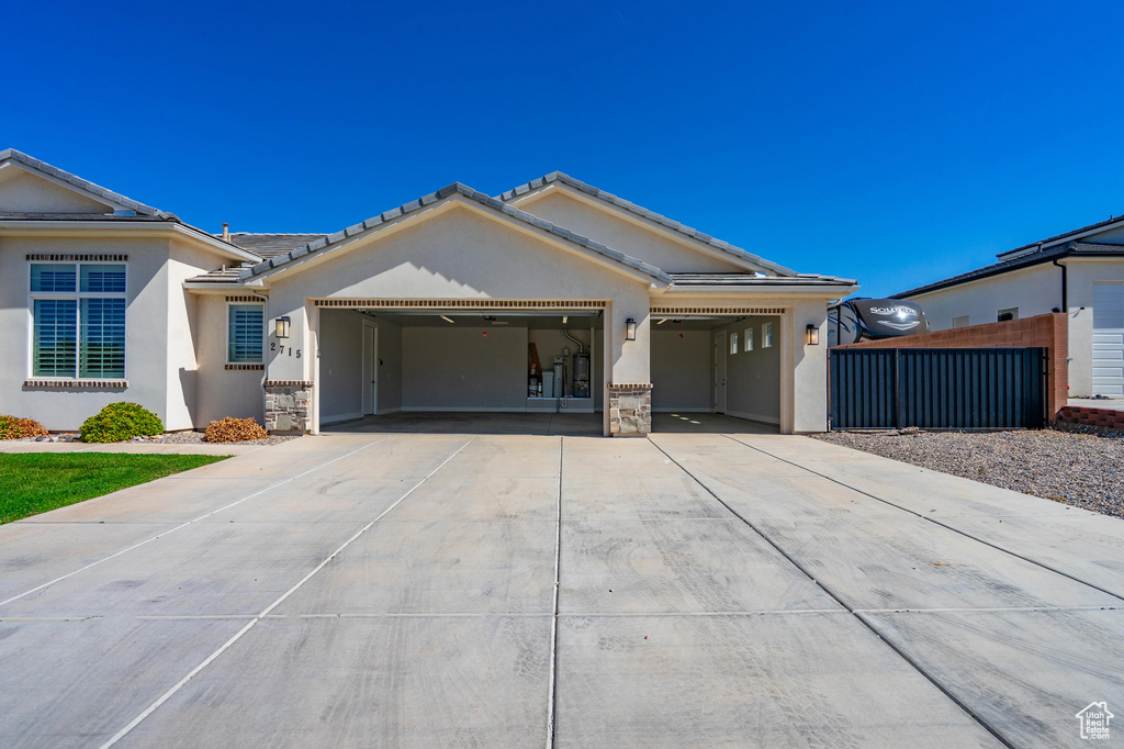 Single story home with an attached garage, concrete driveway, stucco siding, fence, and stone siding