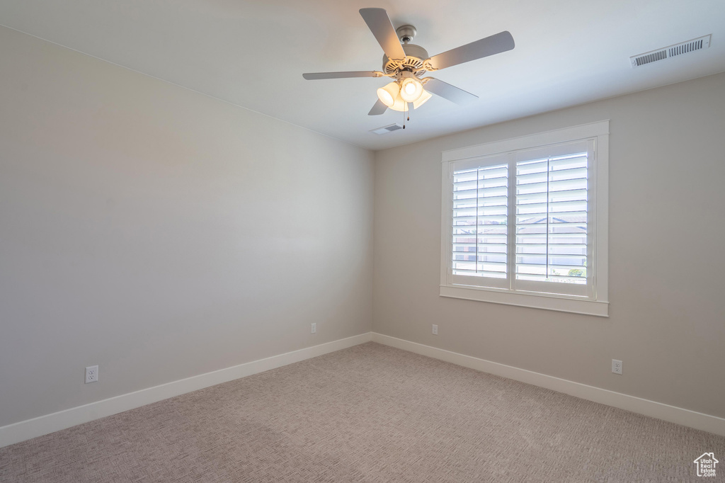 Unfurnished room with baseboards, a ceiling fan, and light carpet