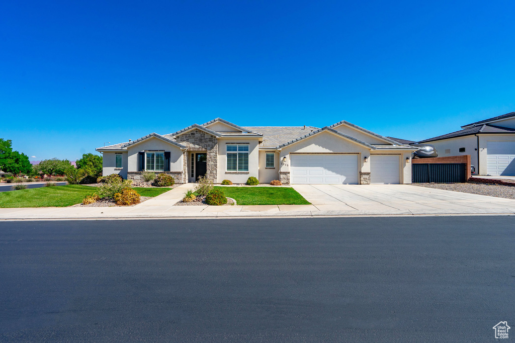 Ranch-style home featuring stone siding, a garage, concrete driveway, and stucco siding