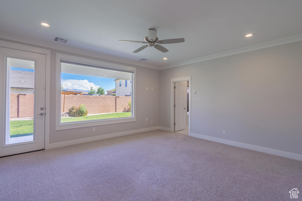 Unfurnished room with crown molding, light colored carpet, a ceiling fan, recessed lighting, and baseboards