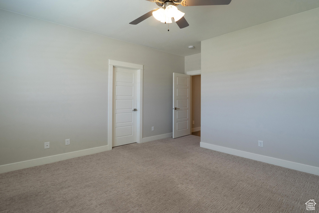 Unfurnished bedroom featuring baseboards, light carpet, and a ceiling fan