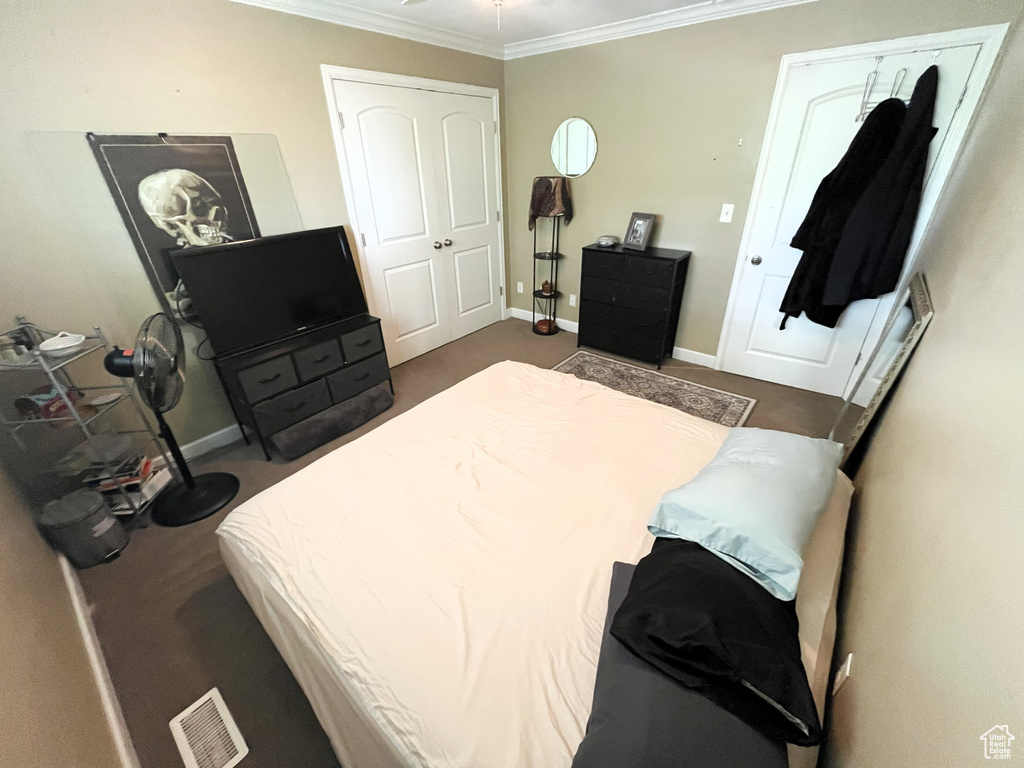 Bedroom with ornamental molding and baseboards