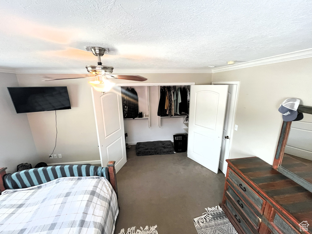 Bedroom with a textured ceiling, crown molding, and a ceiling fan