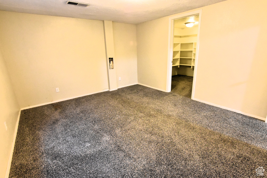 Spare room featuring dark carpet
