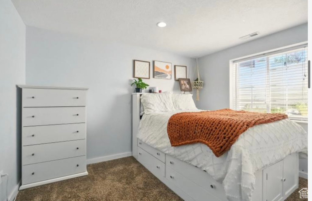 Bedroom with dark carpet, baseboards, and recessed lighting