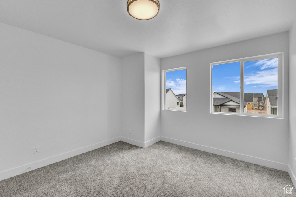 Carpeted spare room with baseboards