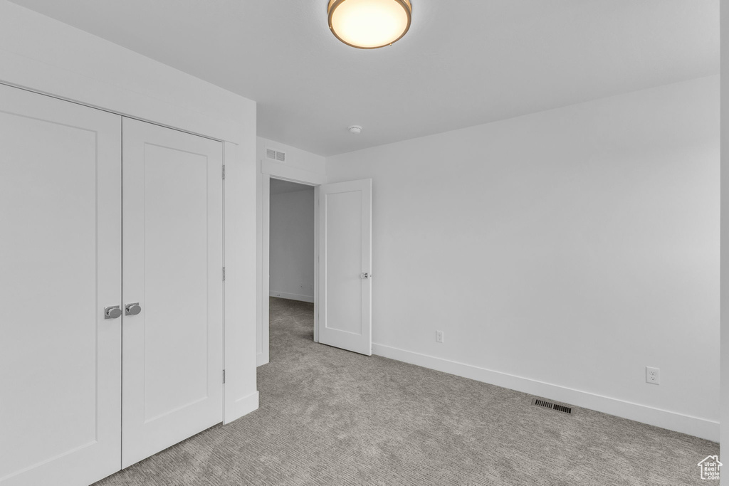 Unfurnished bedroom featuring carpet, baseboards, and a closet