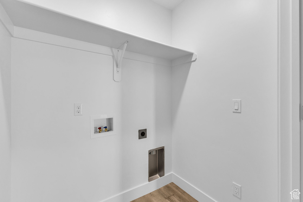 Clothes washing area with washer hookup, baseboards, wood finished floors, and hookup for an electric dryer