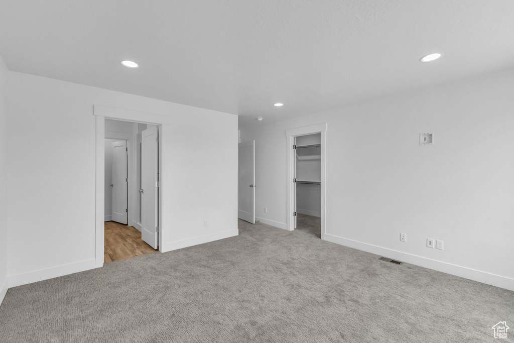 Carpeted empty room featuring recessed lighting and baseboards