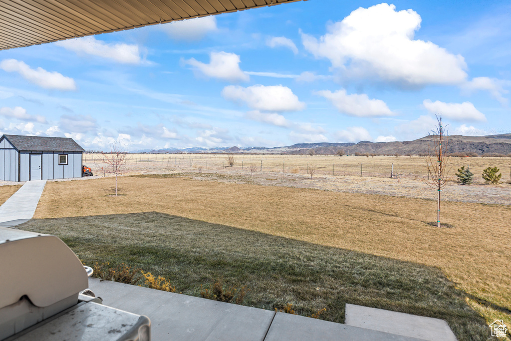 View of yard featuring an outbuilding, a rural view, and a mountain view