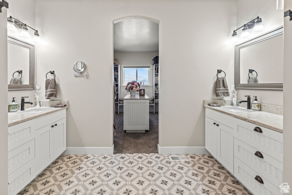 Bathroom with two vanities, baseboards, and tile patterned floors