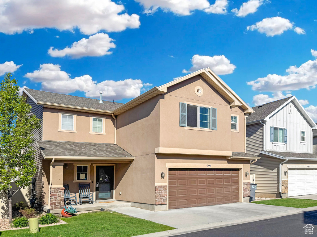 View of property featuring stucco siding, a porch, an attached garage, concrete driveway, and stone siding