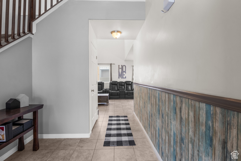 Hallway with a wainscoted wall and tile patterned flooring