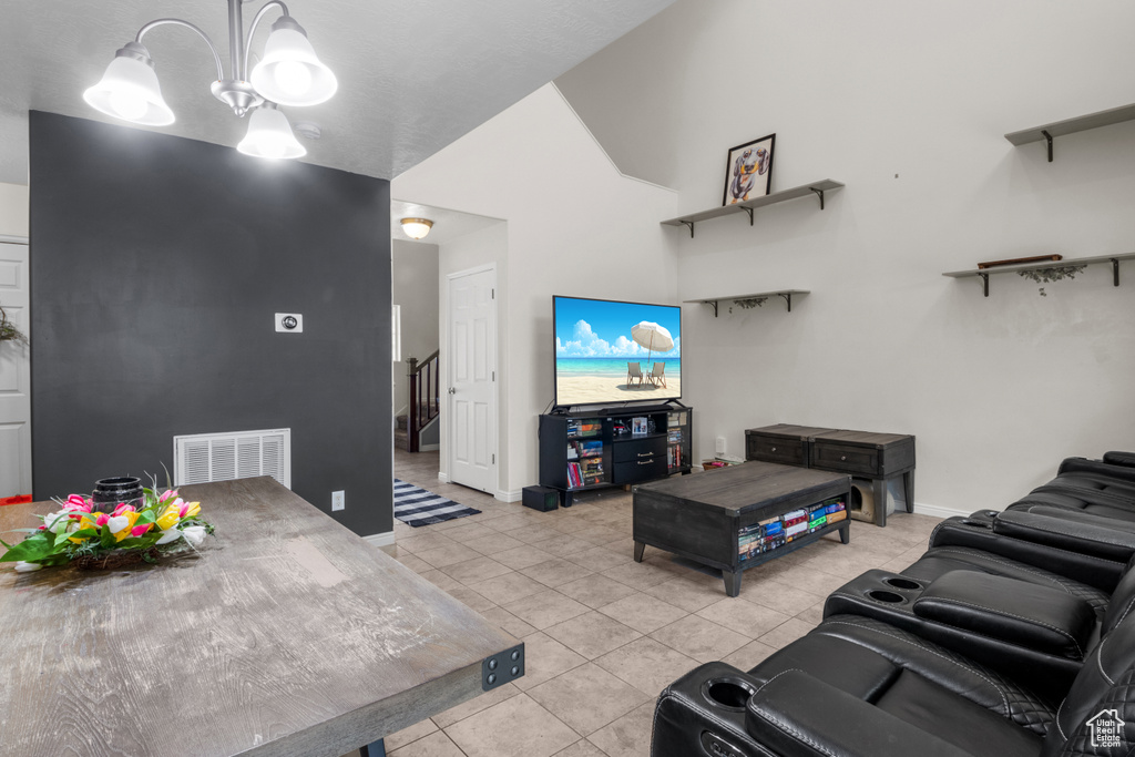 Living room with light tile patterned floors, a chandelier, and baseboards