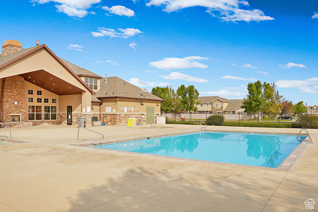 Community pool featuring a patio area and fence