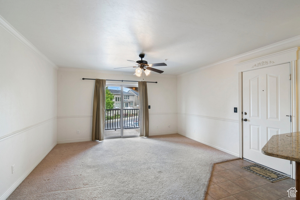 Spare room featuring a ceiling fan, baseboards, ornamental molding, and carpet flooring