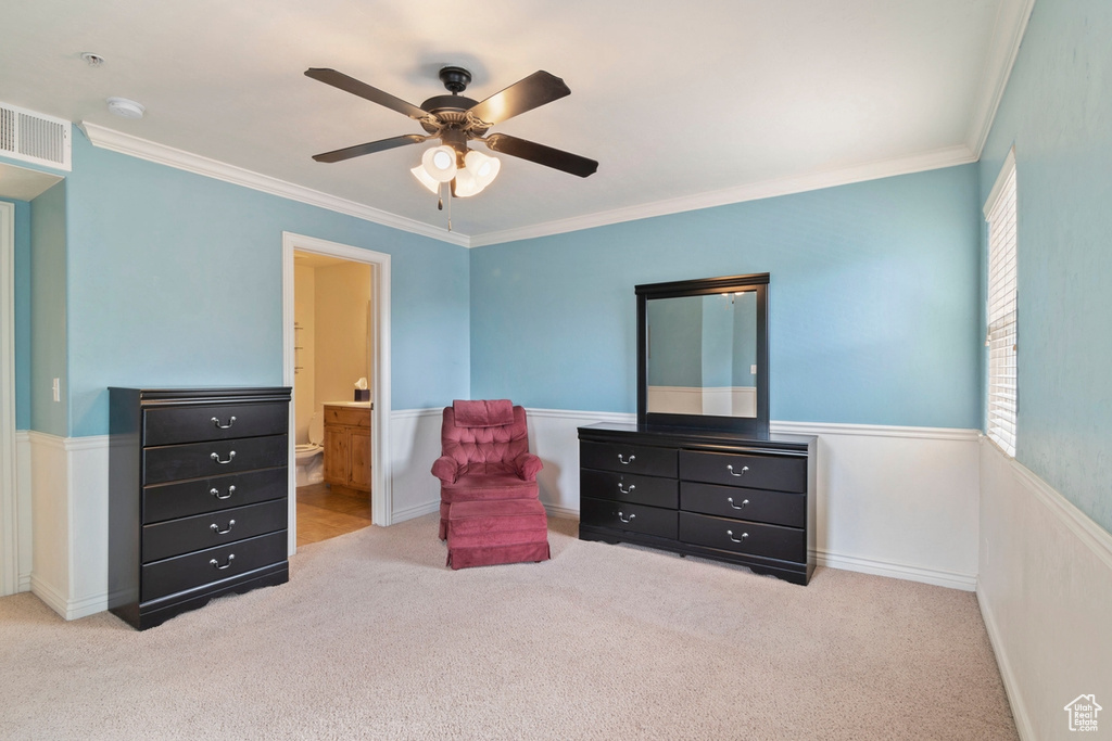 Living area featuring crown molding, carpet, ceiling fan, and a wainscoted wall