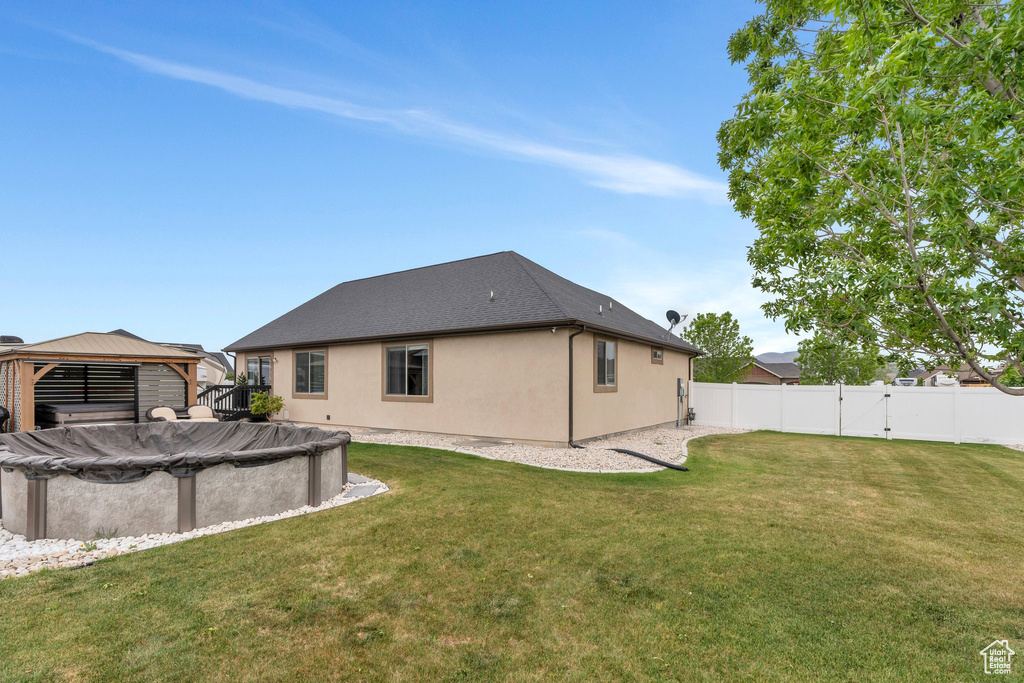 Back of house with a gazebo and stucco siding