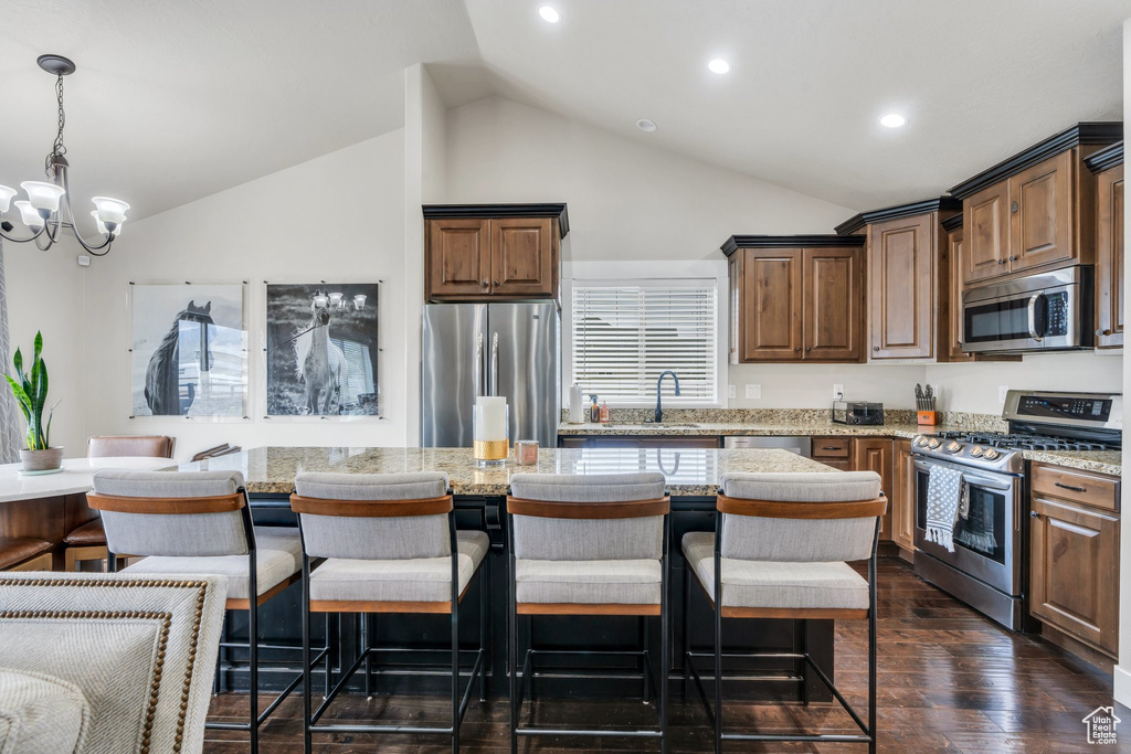 Kitchen featuring appliances with stainless steel finishes, recessed lighting, light countertops, a chandelier, and a breakfast bar area