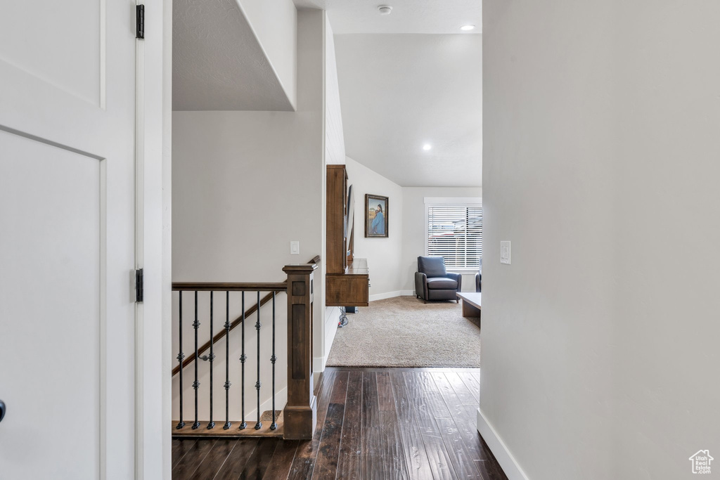 Hallway featuring baseboards, dark wood finished floors, an upstairs landing, and recessed lighting