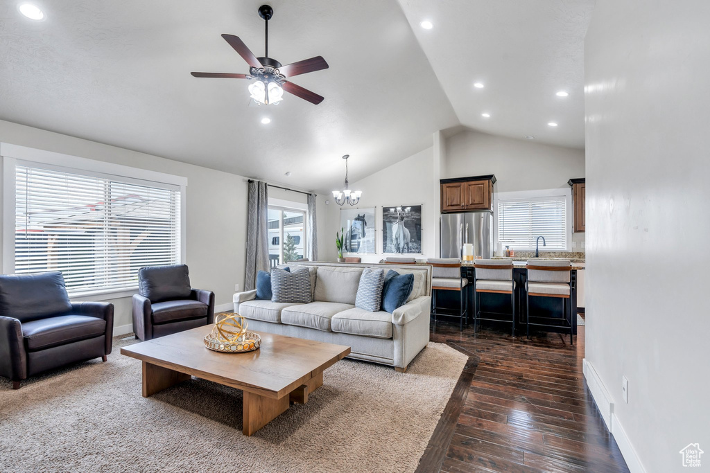 Living room featuring plenty of natural light, baseboards, a chandelier, recessed lighting, and high vaulted ceiling