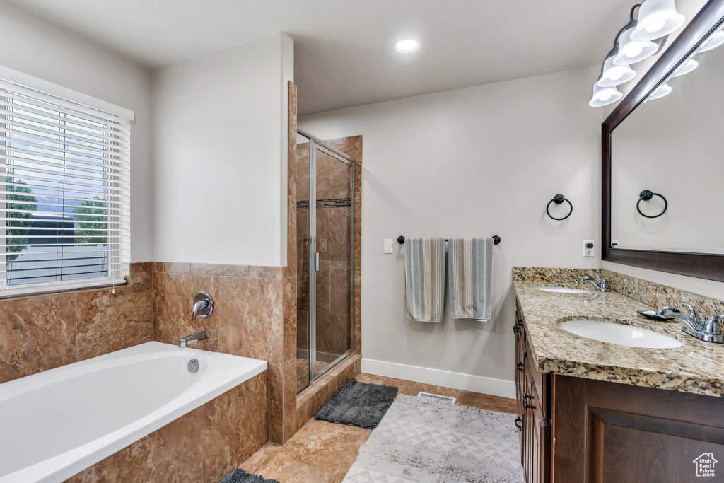 Full bathroom featuring tile patterned flooring, a garden tub, a shower stall, double vanity, and recessed lighting