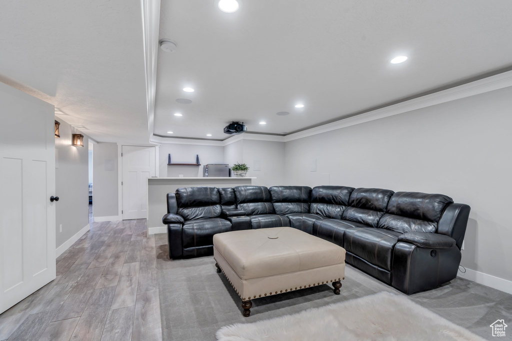 Living area with ornamental molding, recessed lighting, baseboards, and light wood-style flooring