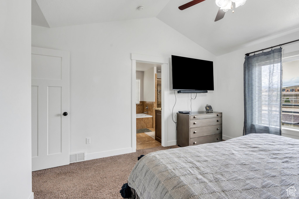 Bedroom with vaulted ceiling, carpet, baseboards, a ceiling fan, and ensuite bath