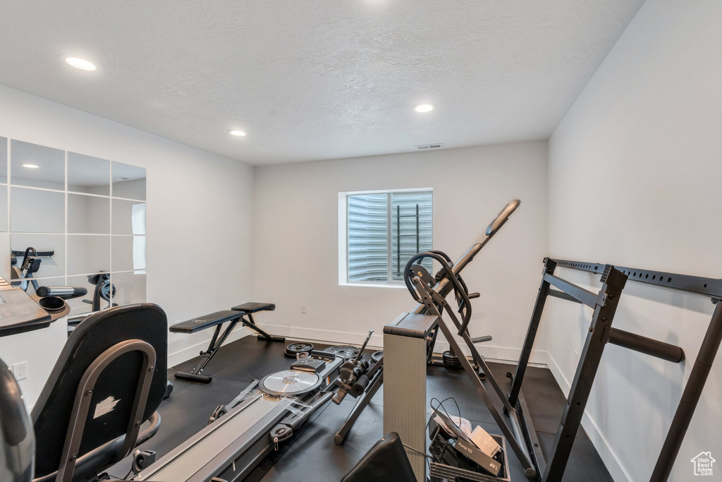 Exercise area featuring recessed lighting, baseboards, and a textured ceiling
