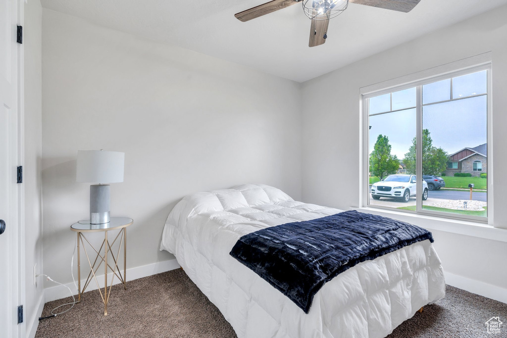 Carpeted bedroom featuring baseboards and a ceiling fan