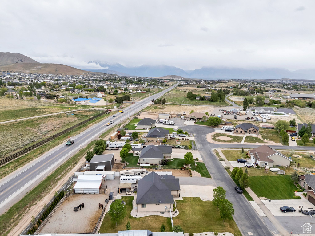 Aerial view of property and surrounding area with nearby suburban area and a mountain backdrop