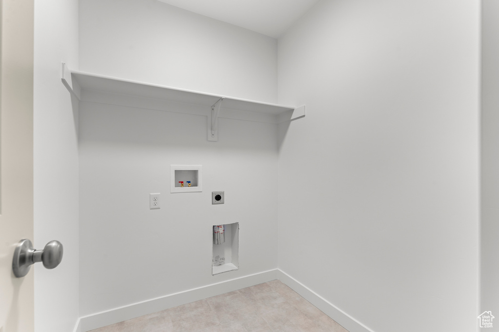 Clothes washing area with baseboards, hookup for an electric dryer, washer hookup, and light colored carpet