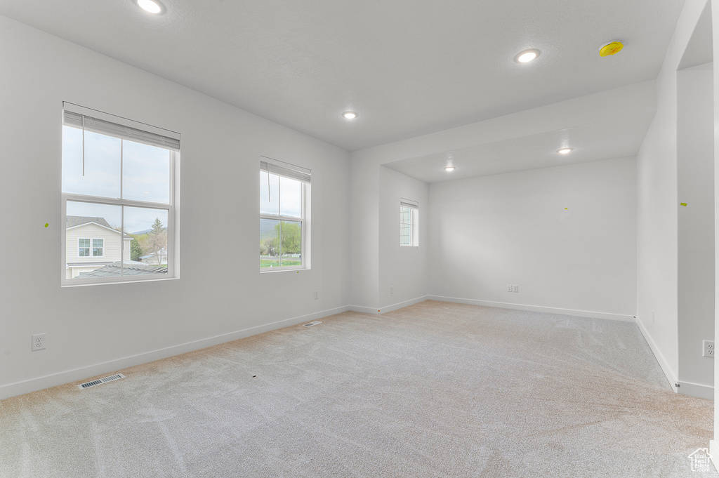 Empty room featuring light colored carpet, recessed lighting, baseboards, and a smoke detector