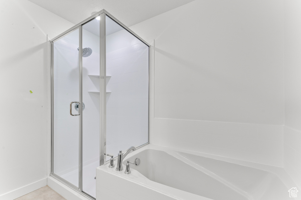 Bathroom featuring a stall shower and a garden tub