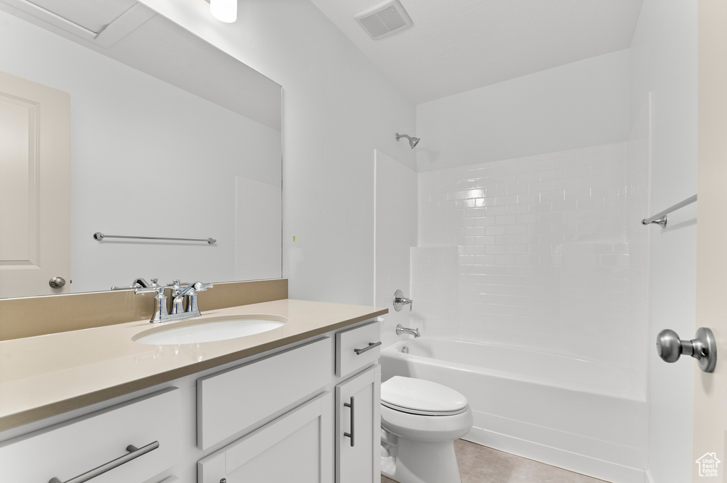Full bath featuring toilet, vanity,  shower combination, and tile patterned floors
