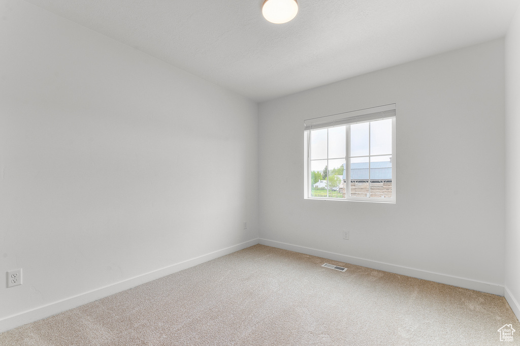 Unfurnished room with light colored carpet and baseboards