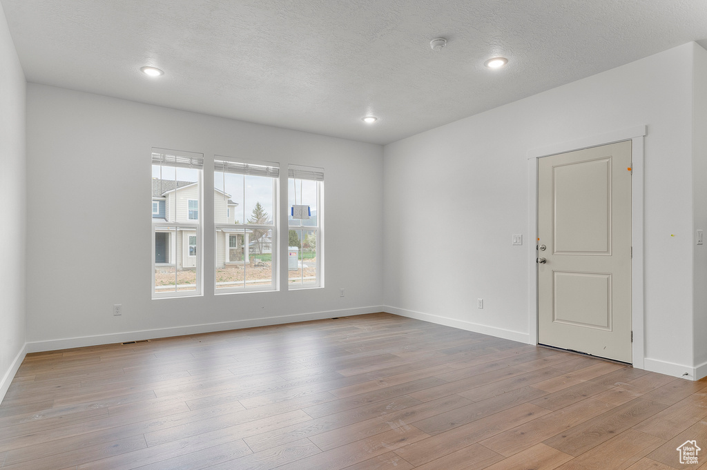 Spare room featuring baseboards, light wood-style floors, recessed lighting, and a smoke detector