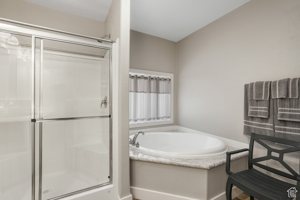 Full bath with a shower stall and a bath