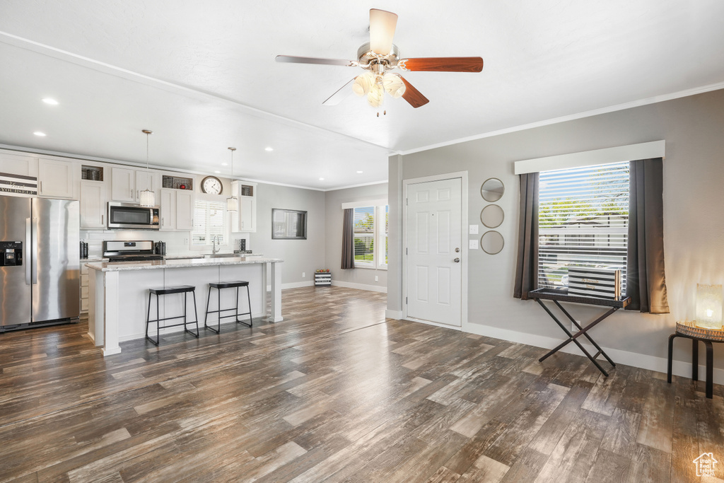 Foyer entrance featuring dark wood-type flooring, recessed lighting, ornamental molding, baseboards, and a ceiling fan