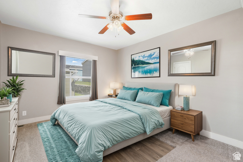 Bedroom featuring baseboards, a ceiling fan, and light colored carpet