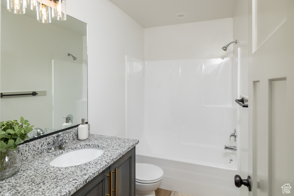 Bathroom with shower / bathtub combination, toilet, and vanity