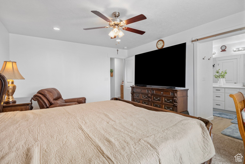 Bedroom featuring a ceiling fan, ensuite bath, and recessed lighting