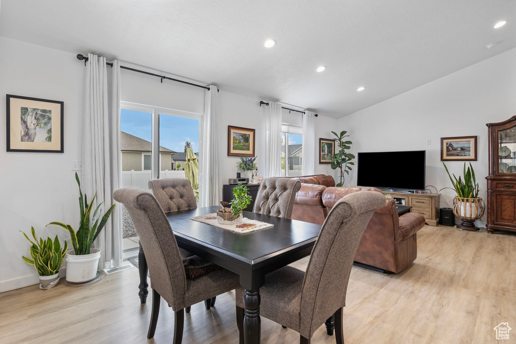 Dining space featuring light wood-type flooring, recessed lighting, vaulted ceiling, and baseboards